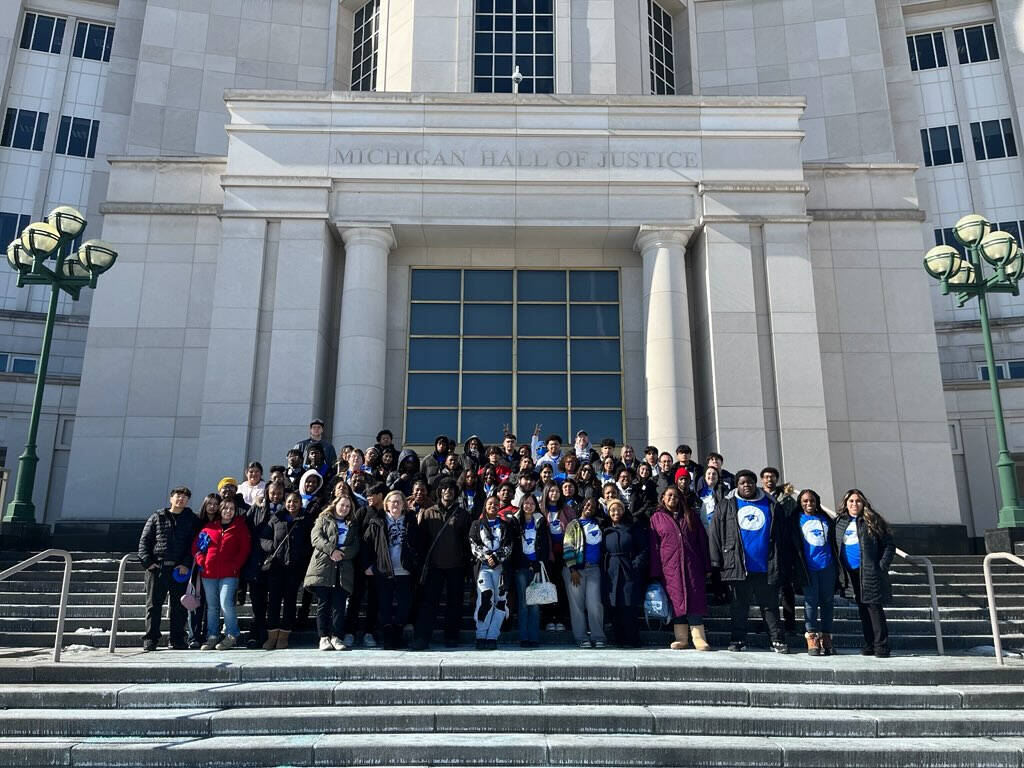 Group of students standing on stairs looking at camera